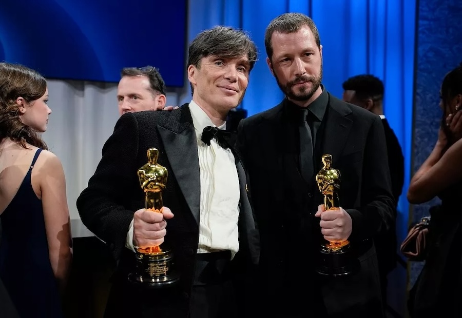 Director Mstyslav Chernov seen holding his Oscar next to Cillian Murphy