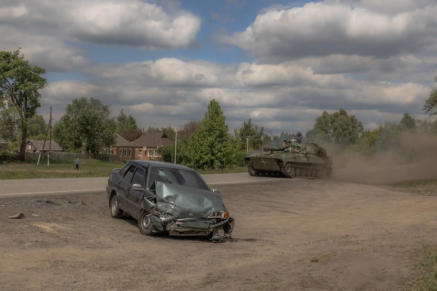 Український танк у неділю біля пошкодженого автомобіля у Вовчанському районі Харківської області
