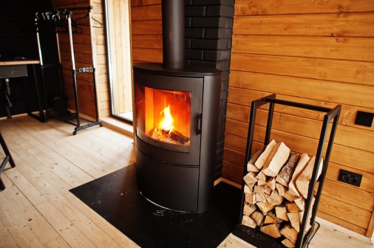 Fireplace with woods in modern wooden house.